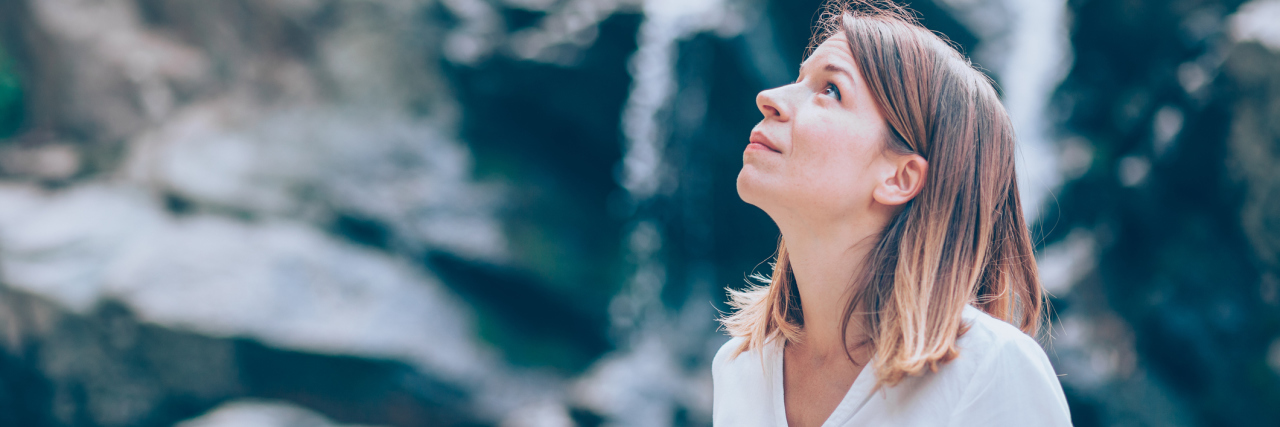 The Common Question I Dread When My Health Temporarily Improves A woman outside, looking to the sky.