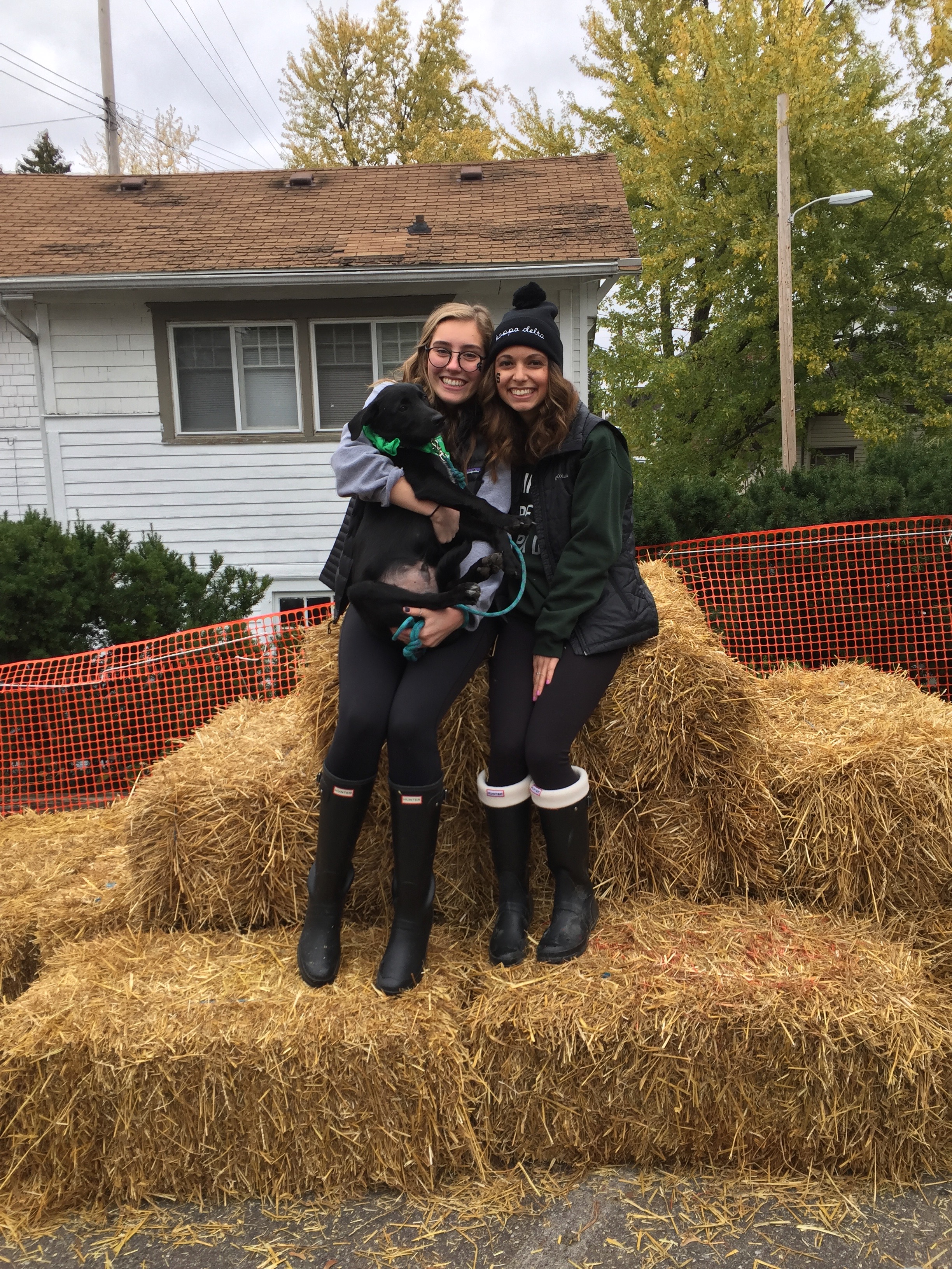 The writer with a friend, standing on a hay bale. 