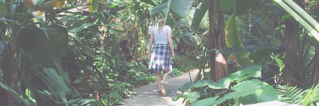 Why We Shouldn't Blame Chronically Ill People for Their Illness woman walking down a path in a forest surrounded by leaves