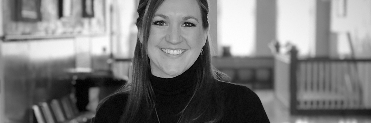 black and white photo of a woman posing and smiling