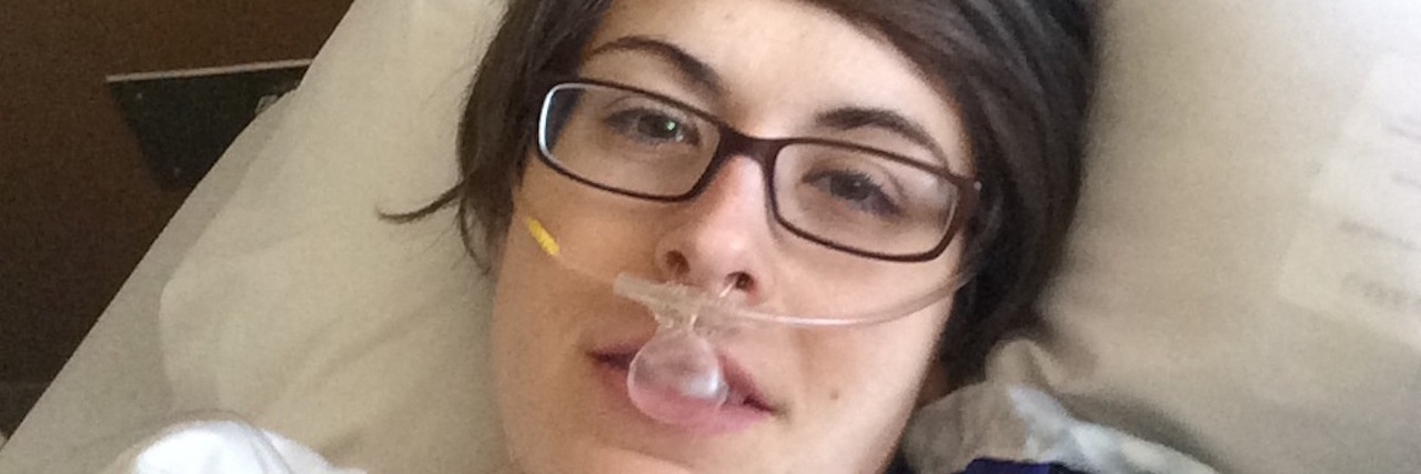 The Messy Catch-22 Situation of Living With Endometriosis and OCD A photo of the writer in a hospital bed, wearing oxygen.