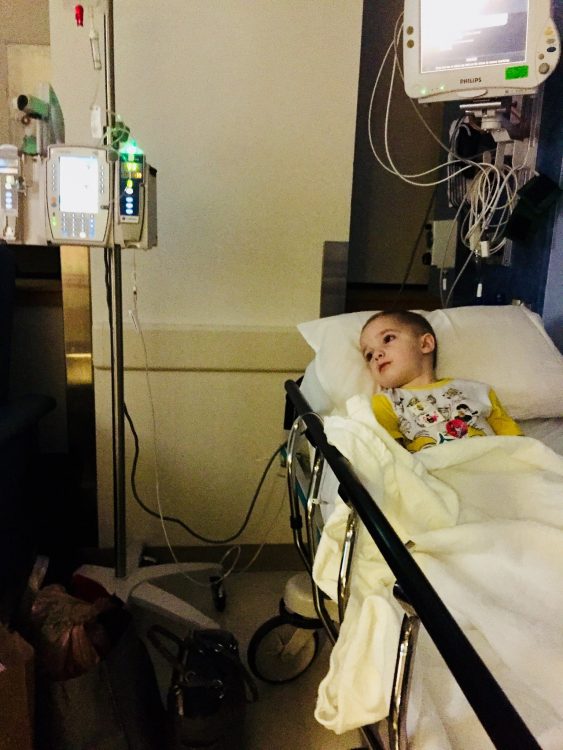 Kendal's son laying in a hospital bed connected to an IV