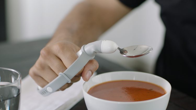man using liftware level spoon to eat soup