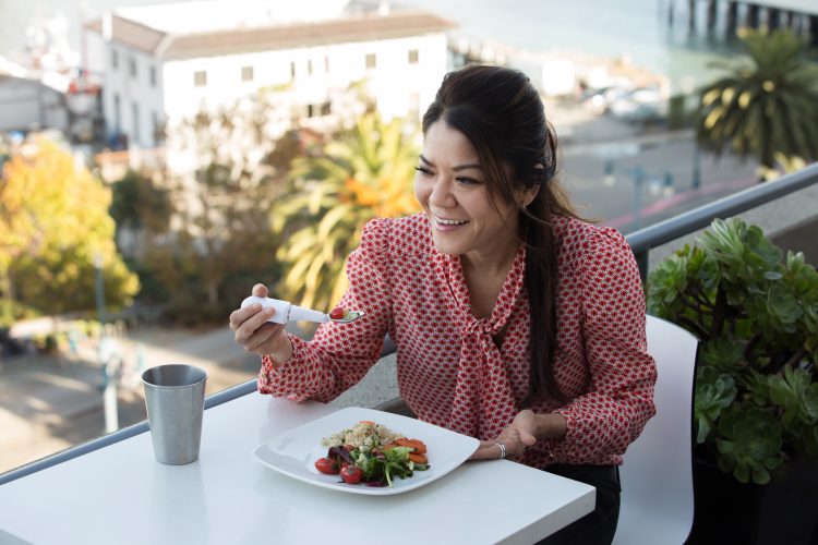 woman using liftware steady utensil to eat