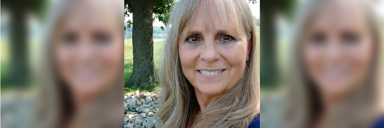 How Changing Your Mindset Can Help You Battle Chronic Illness photo of the author smiling outside wearing a blue shirt