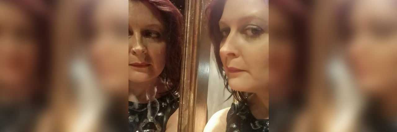 Dealing With the Unpredictability of Fibromyalgia the author taking a photo with her face reflected in a mirror
