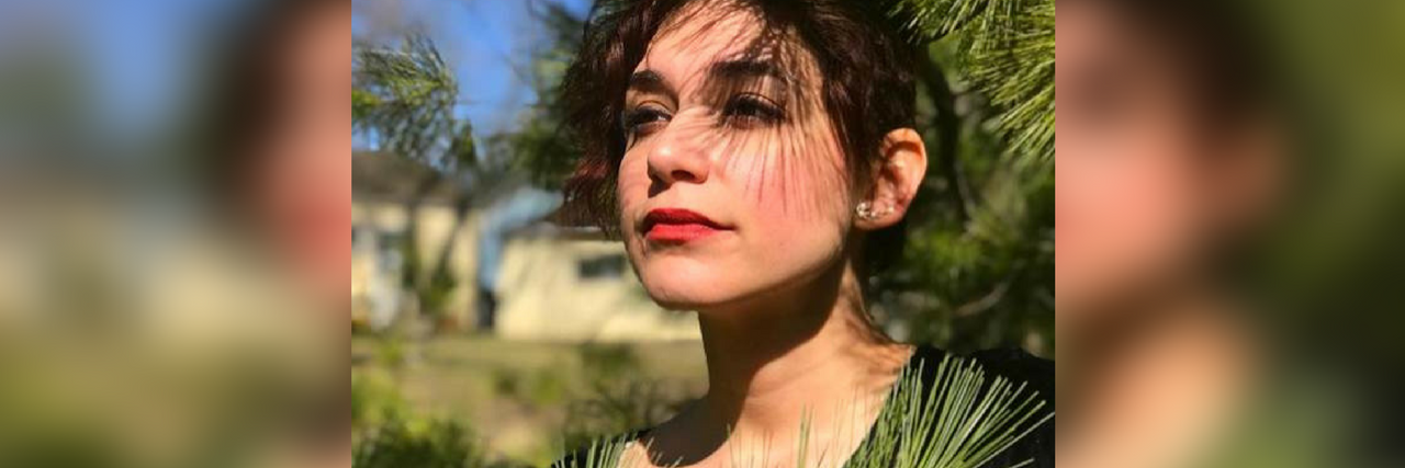 When People Don't Believe Your Illness and Judge You photo of author standing outside behind a tree branch