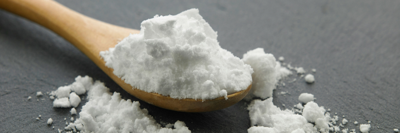Researchers Think Drinking Baking Soda May Treat Autoimmune Disease Wooden spoon with baking soda