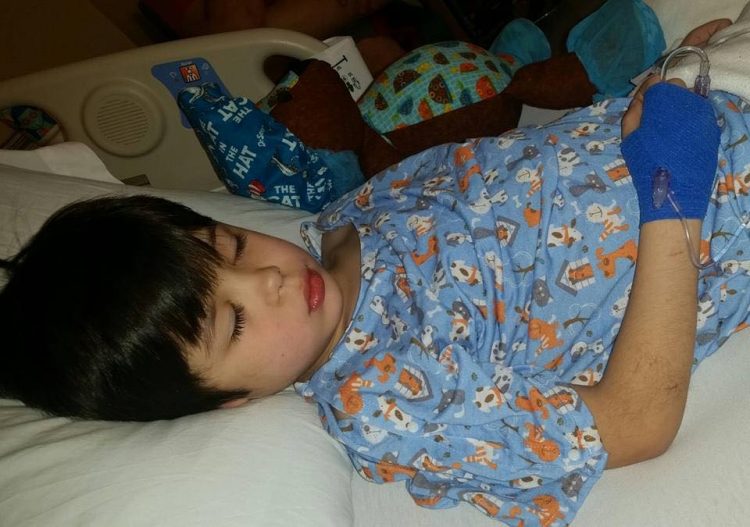 Valerie's son laying in a hospital bed