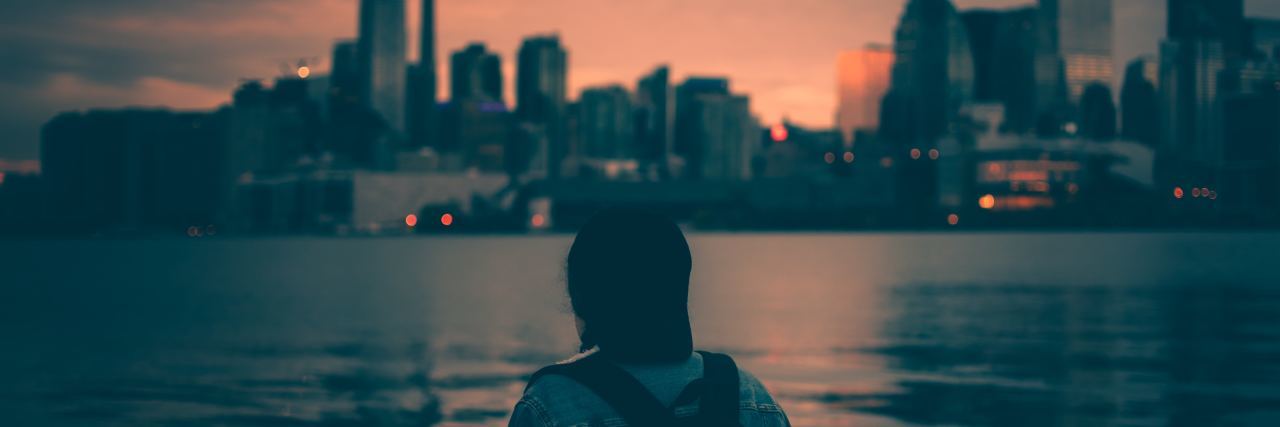 How the Toronto Attack Made Me Realize My Own Mental Health Stigma young woman wearing backpack looking at Toronto skyline at sunset