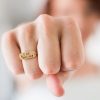 woman with fist towards camera showing ring that says I am badass