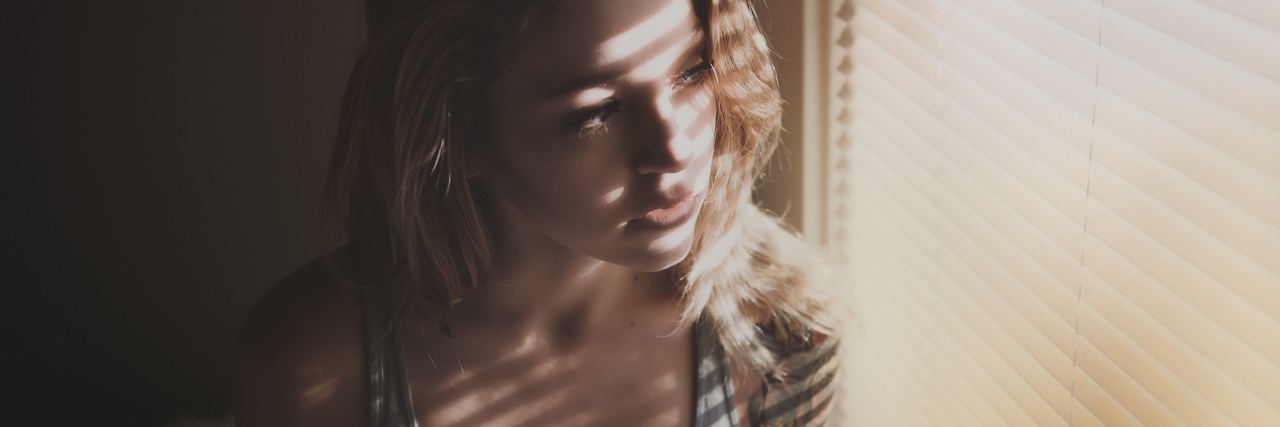 I 'Should' Be Able to Work, but I Can't Because of Mental Illness woman looking out window