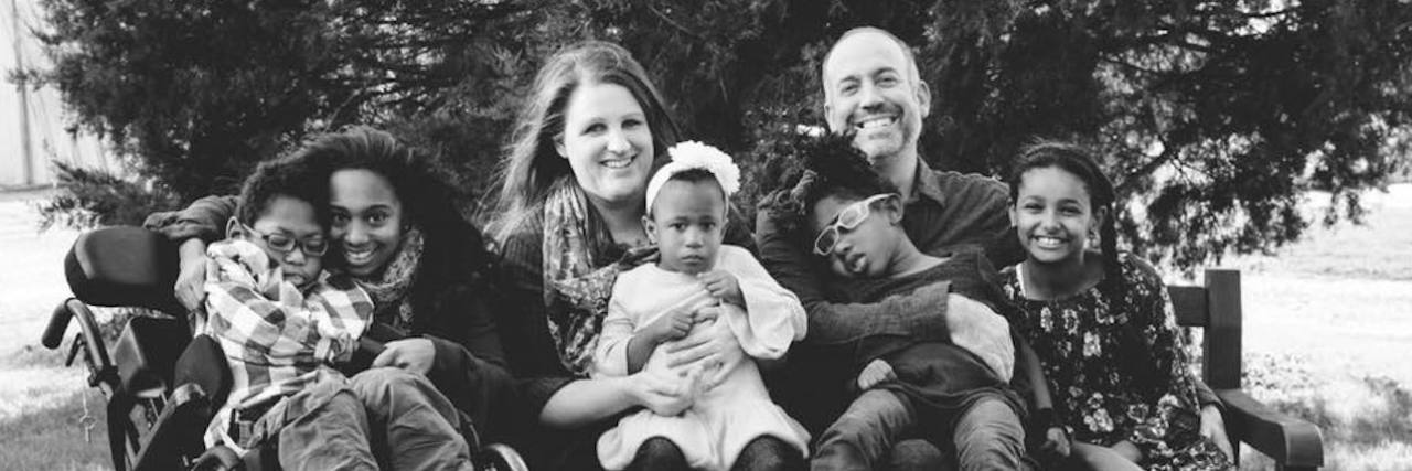 Choosing to Do Foster Care for Medically Fragile Children Black and white image of large family; family of 7, several kids with disabilities