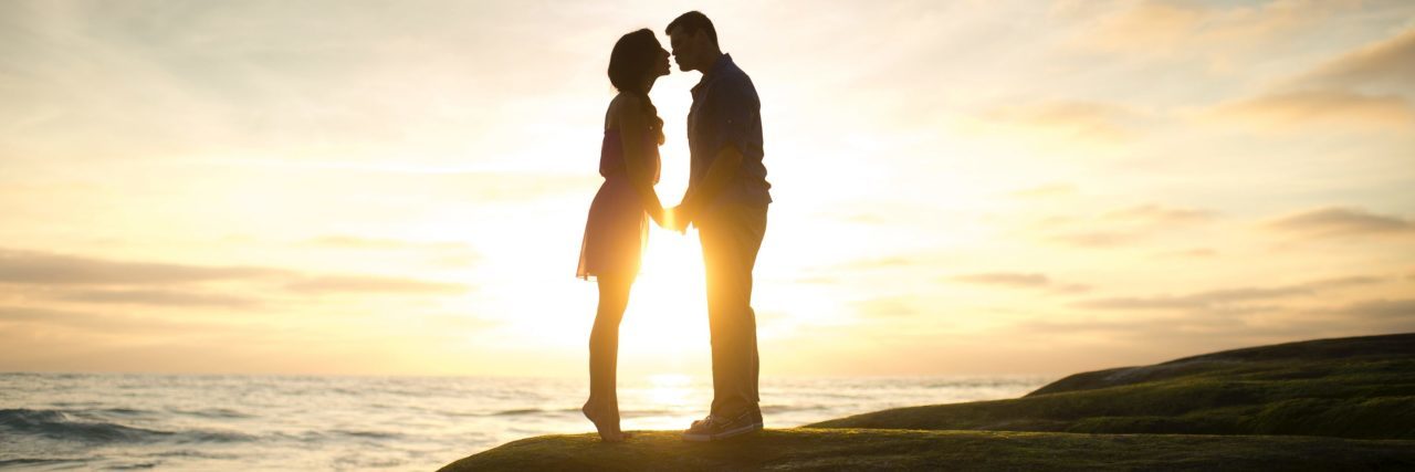 What You Need to Know About Loving Someone With Bipolar II Disorder couple silhouetted against sunset with woman on tip toes to kiss man