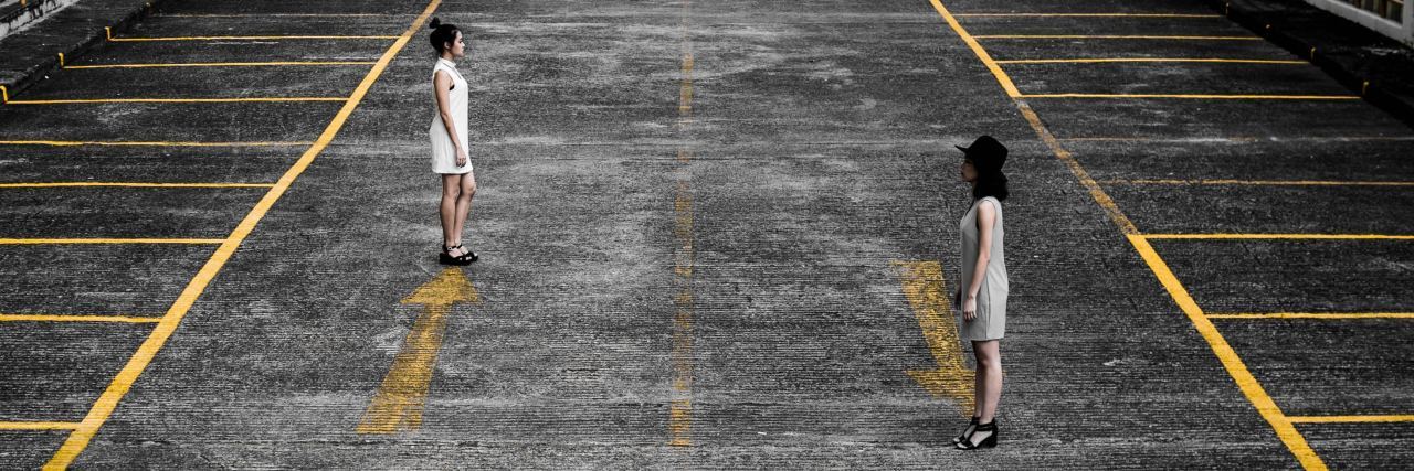 When Depression Makes You Live in Opposites two women standing on car park roof with opposite lines and arrows