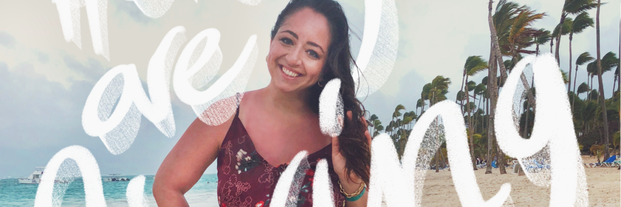 Living a Limitless Life With Chronic Pain woman wearing a dress and smiling on the beach with the words 'here you are living despite it all'