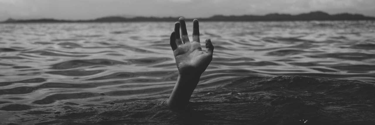 Why Depression Is a Black and Stagnant Sea ocean with storm overhead and person's hand under water reaching for help