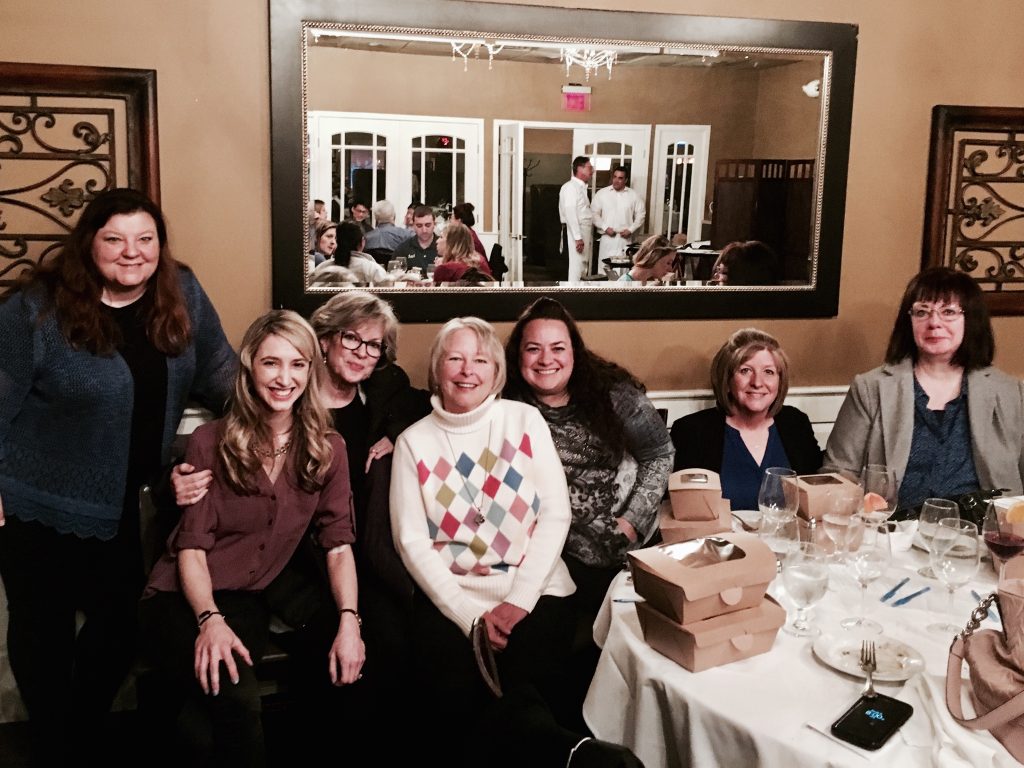 group of women sitting together in a restaurant and smiling