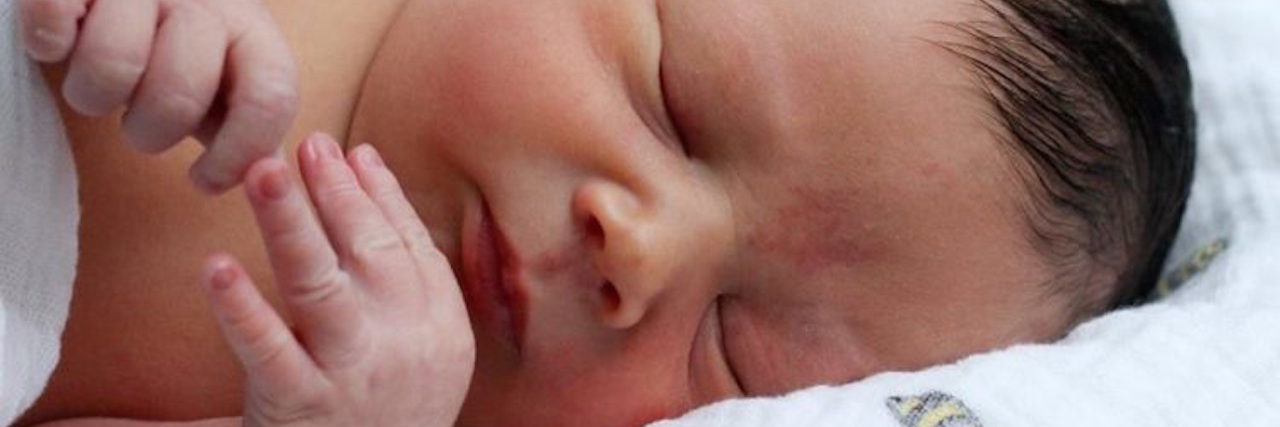 Parenting a Child Who Is Undiagnosed author's baby at birth, wrapped in a blanket