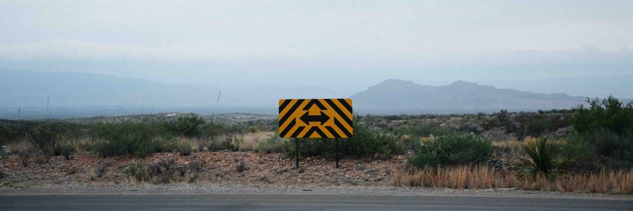 Common Misconceptions About Chronic Pain photo of a sign with arrows pointing left and right against a gloomy sky