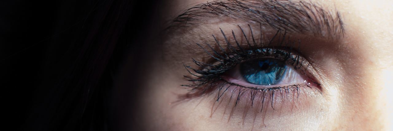 20 Things I Want You to Know as Someone Who's Survived Rape a woman whose blue eye is illuminated by light