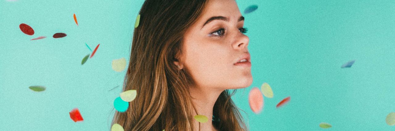 How to Improve Your Memory (From Someone With Synaesthesia) woman against blue background with colors falling around her