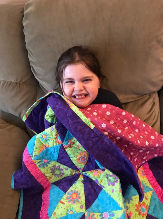 girl smiling with quilt
