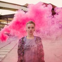 woman standing in front of a cloud of pink smoke