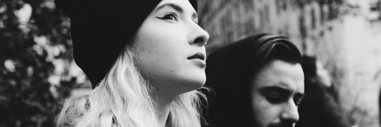 The Code Words I Use to Tell My Partner They've Triggered My PTSD woman wearing beanie and man wearing hood