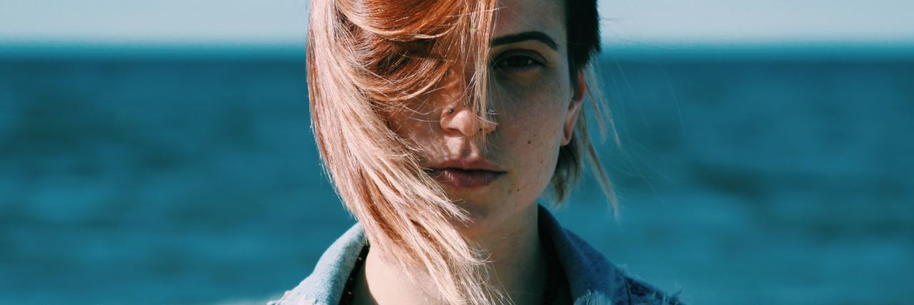The Small Steps I'm Taking to Accept My Weight Restored Body woman at beach with red hair waving in her face