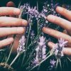 close up of woman's hands holding purple flowers