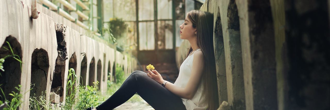5 Ways I Calm Down When I'm Feeling Triggered woman sitting in abandoned building with grass