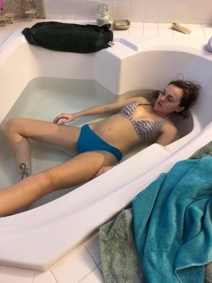 woman lying paralyzed in a bath tub