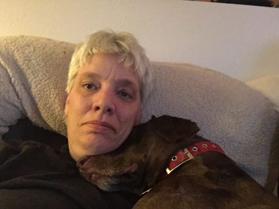 woman lying in bed with her dog