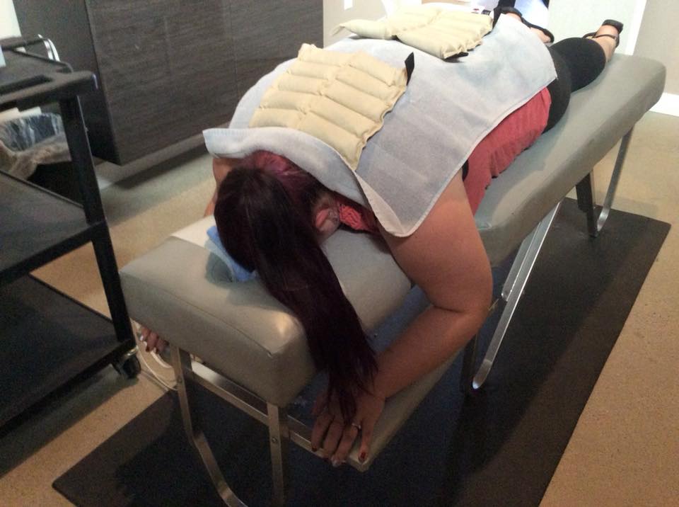 woman lying face down on a table at the chiropractor's office