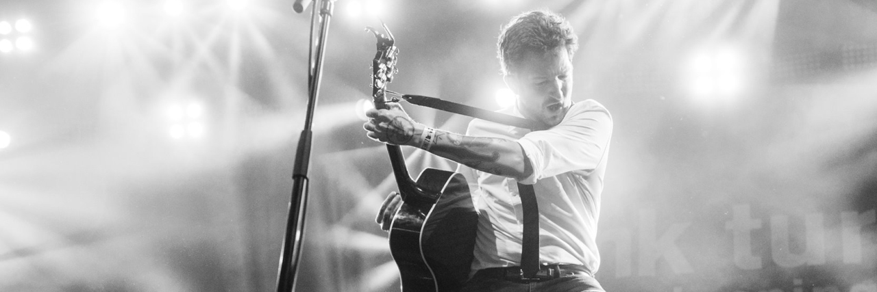 Open Letter to Frank Turner About Music Venue Disability Access Frank Turner rocking out on guitar at a concert.