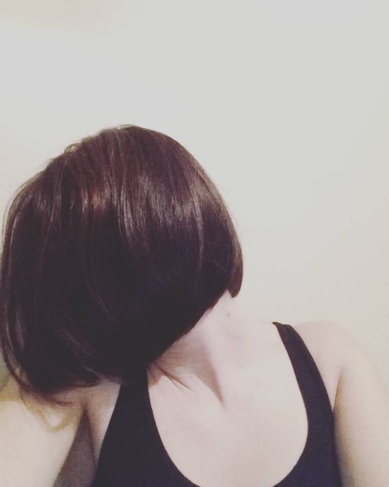 woman with short brown hair turning away so her hair covers her face