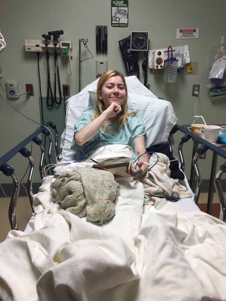 woman sitting in a hospital bed and smiling