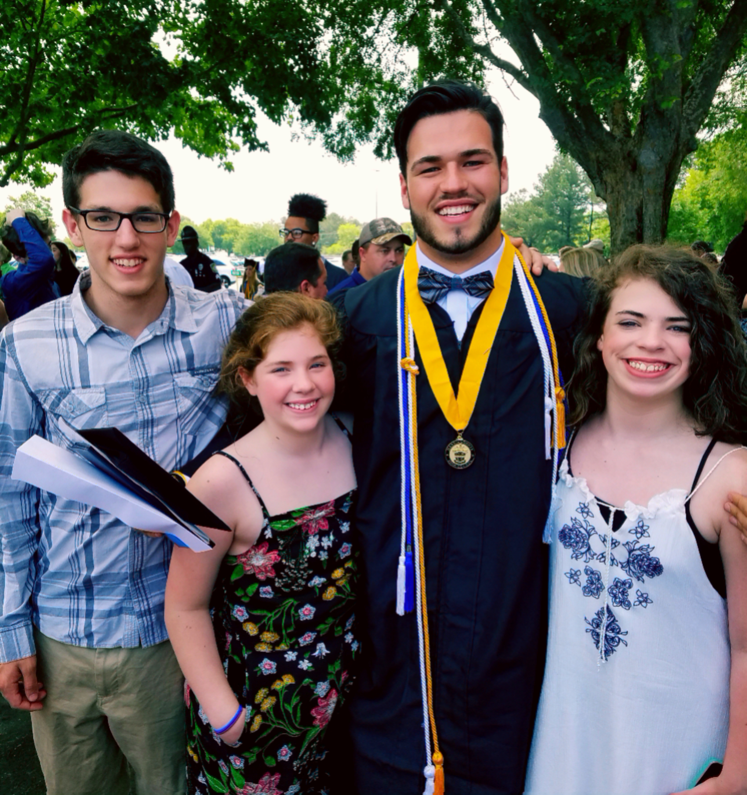 A photo of the writer's four children, one wearing a graduation robe.