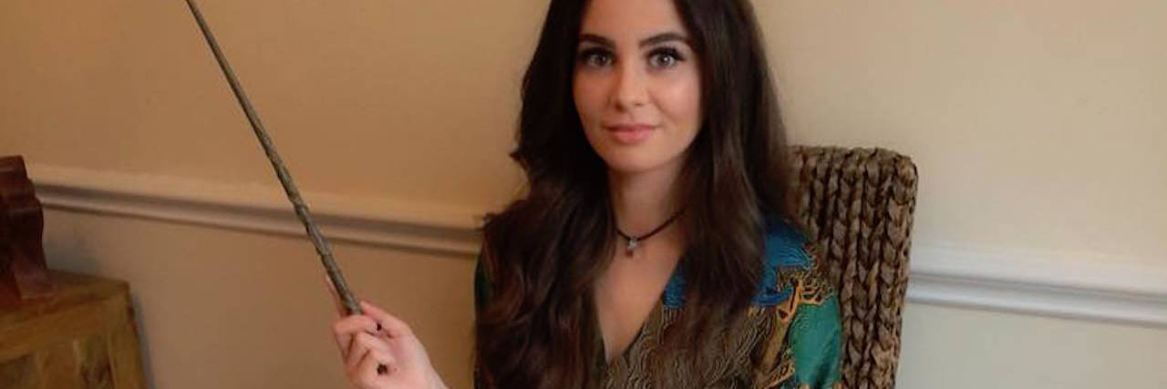 Why I Started the 'All About M.E. Knitathon' for ME/CFS woman sitting at a table covered in colorful knitting squares