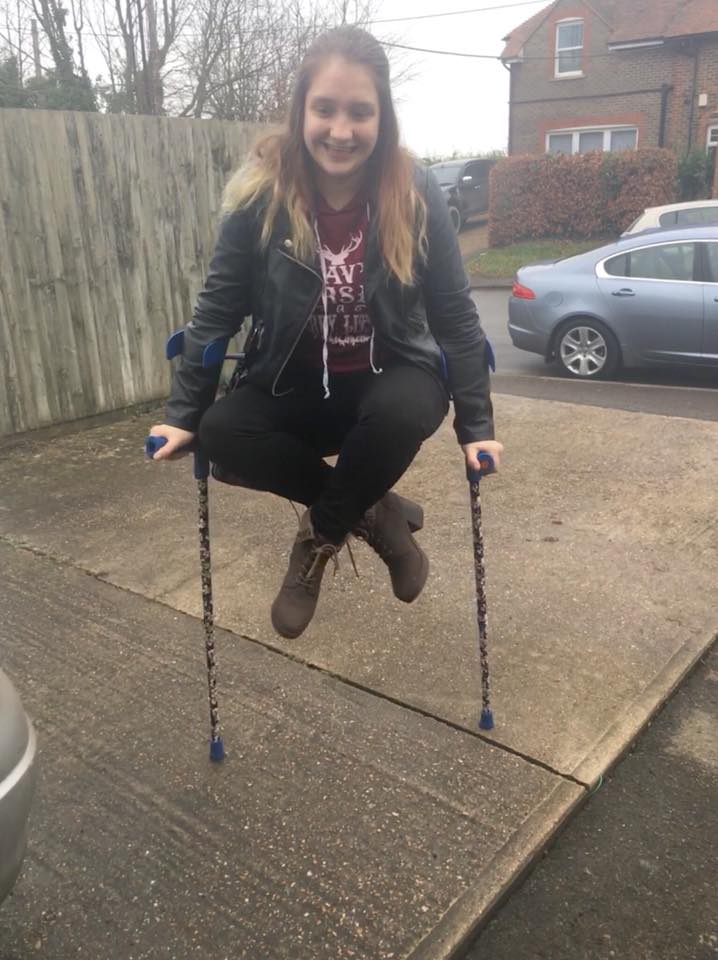 woman holding herself in the air by balancing on her two crutches
