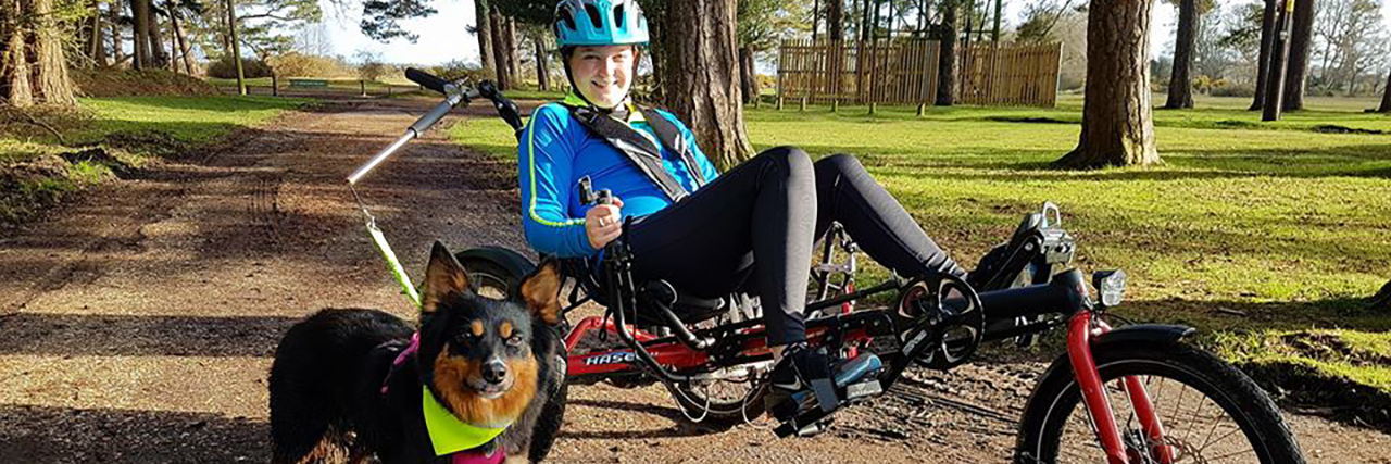 Dog Attacks on Assistance Dogs Megan riding her bike with Ruby by her side.