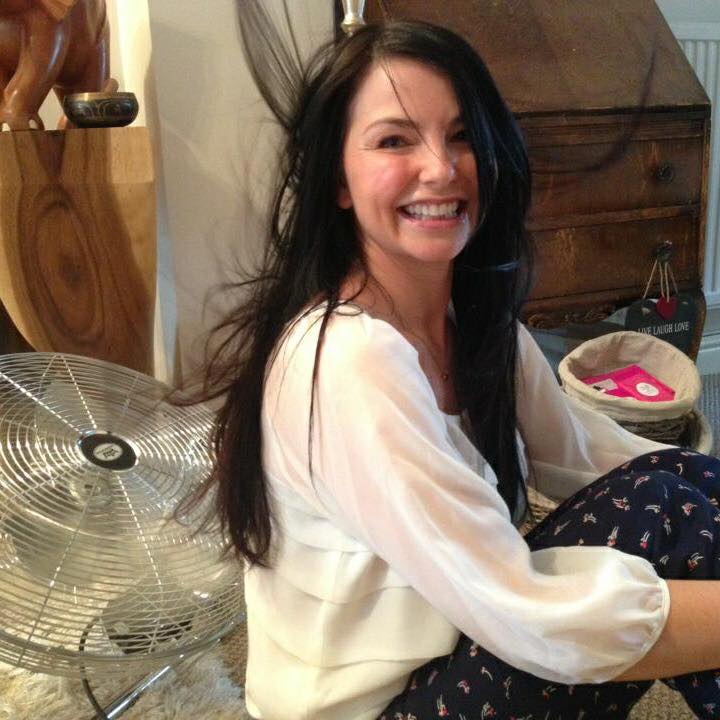 woman sitting in front of fan on floor