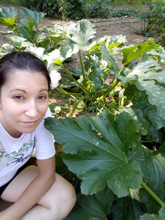 woman kneeling next to plants