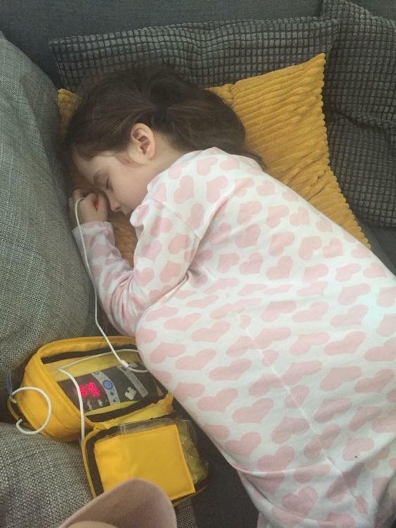 Donna's daughter lying on the couch attached to medical equipment