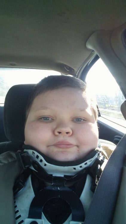 author's son with a neck brace in the car