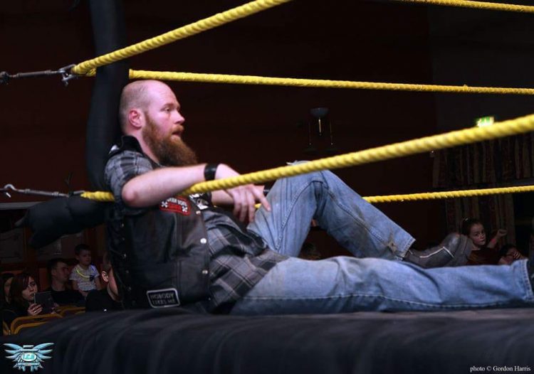 A man sitting in a boxing rink