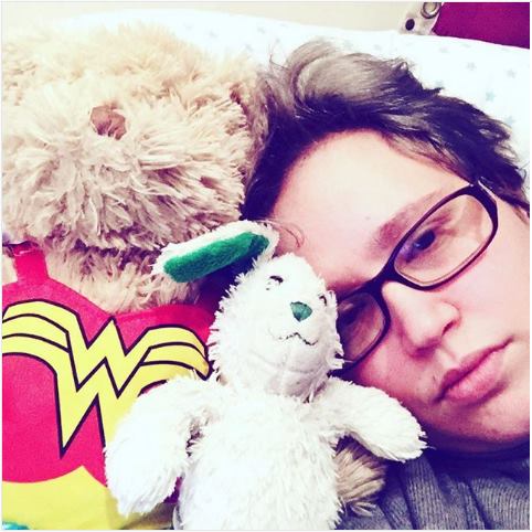 person in bed with two stuffed animals