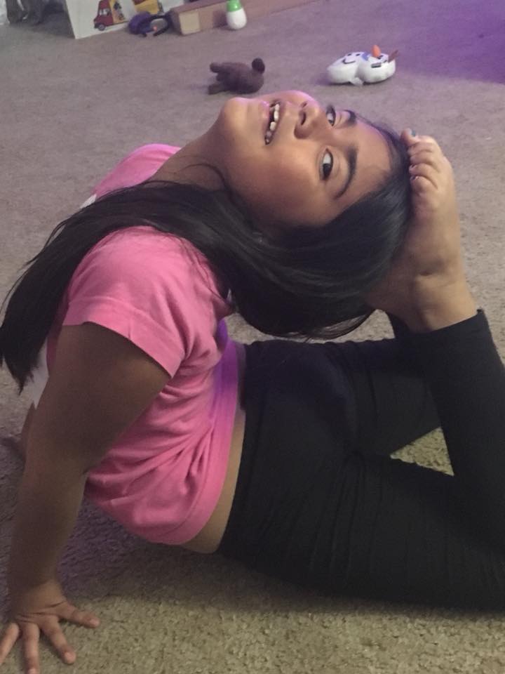 young girl stretching to touch her head to her toes