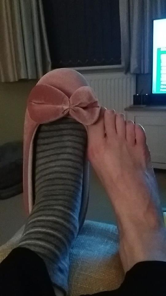 woman's feet. one is bare, and the other has on a sock and slipper